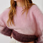 A woman models the Sablyn June Ombre Crewneck Sweater—a fuzzy, color-blocked raglan style in pink and burgundy—paired with loose cream pants, shown from shoulders to hips against a plain background.