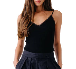 Model wearing the Sablyn Ada V-Neck Cami with Lace, styled with high-waisted dark pleated pants, hands in pockets; shown from shoulders to hips.