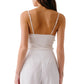 A woman is seen from the back wearing the Ada V-Neck Cami with Lace by Sablyn and high-waisted white pants against a plain background.