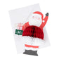 The Honeycomb Santa Stand Up Card by Meri Meri features a 3D honeycomb effect with Santa holding two gift boxes and a red and white honeycomb-patterned belly, making it the perfect Christmas decoration. Comes with an envelope.