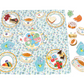 The Eeboo Tea Party Spinner Game features a floral-patterned play set with illustrated tea cups, plates, tea-time treats, and a teapot spinner on a blue and white fabric tablecloth.