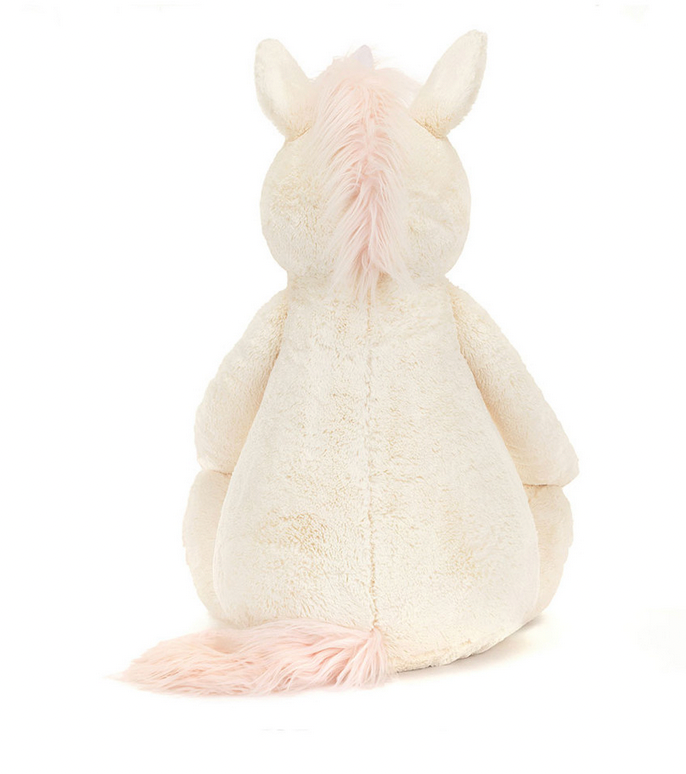 Back view of Jellycat Bashful Unicorn, Giant by Jellycat, a plush toy featuring vanilla fur with a white body and pale pink mane and tail, sitting upright with a holographic horn gleaming.