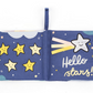 A colorful, interactive fabric children's book, the Jellycat Hello Moon Fabric Book by Jellycat, features a page with smiling yellow stars and another page with a shooting star and the text "Hello stars!" against a blue backdrop, perfect for baby exploration.