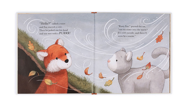 Children's book illustration showing a red fox and a gray cat outside in a windy scene with falling leaves. Text reads, "Hello?" called a voice. "Rusty Fox," purred the cat, "Can we come into the warm?" This giftable hardback, Jellycat Warm in the Storm Book by Jellycat, makes for a perfect bedtime story.