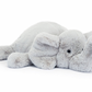 A Jellycat Wanderlust, this plush toy elephant lies on its side with its trunk curled upward, perfect for any adventurer.