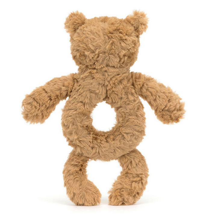 A fuzzy brown bear-shaped stuffed toy, crafted from recycled fibers, features a circular hollow in its torso and is shown displaying its back. The product is the Jellycat Bartholomew Bear Ring Rattle by Jellycat.