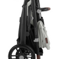 A folded black UPPAbaby Vista V2 Stroller with brown leather accents, featuring large wheels and a white cloth draped over the side. This versatile stroller from UPPAbaby offers multiple configurations, including a bassinet suitable from birth and a toddler seat that supports up to 50 lbs.