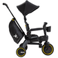 The DOONA Liki Trike - Midnight Edition by Doona is a black tricycle stroller with yellow accents that includes a cup holder, sun canopy, and a storage bag attached to the handle. This compact folding trike is the ideal stroller alternative for active parents.