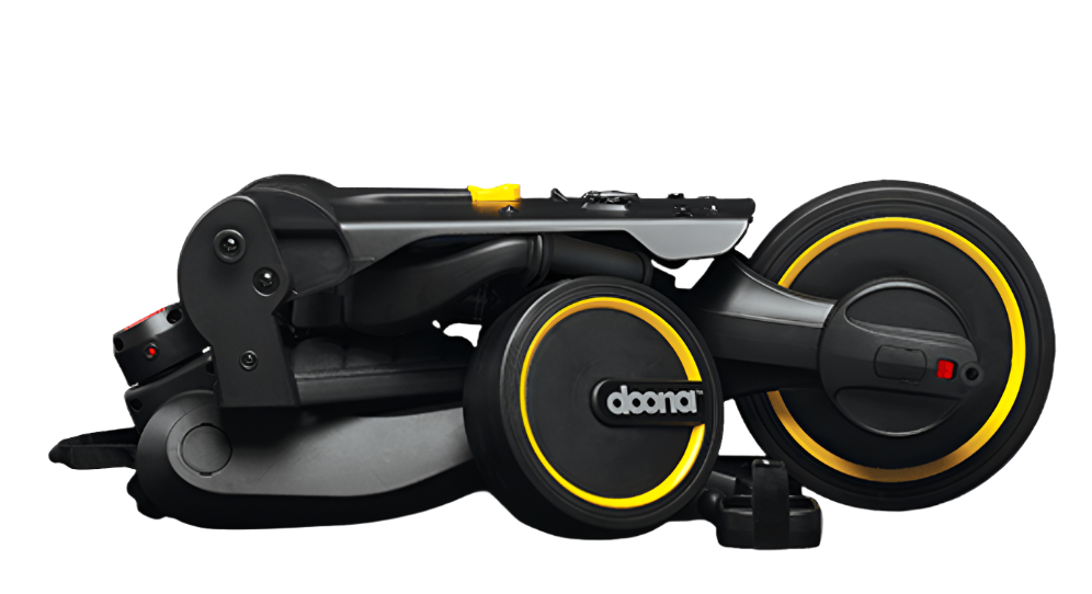 A folded black and yellow DOONA Liki Trike - Midnight Edition, showcasing its compact form against a white background.