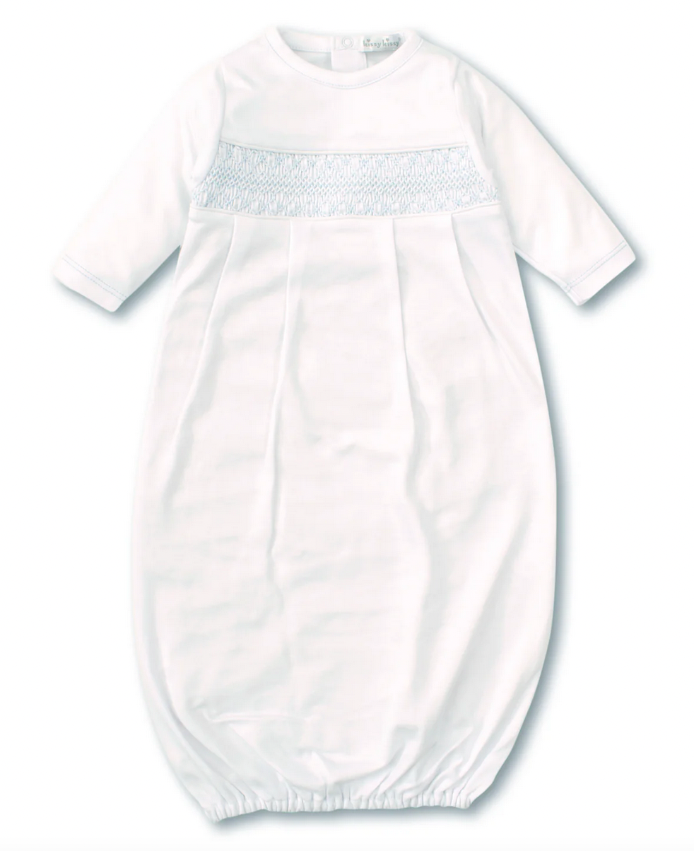 The Kissy Kissy Sack Gown with Hand Smocked, by Kissy Kissy, is a white baby gown with long sleeves made from soft Peruvian cotton. It features a hand-smocked panel across the chest and an elastic hem at the bottom.