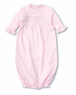 The Kissy Kissy Sack Gown with Hand Smocked by Kissy Kissy is a light pink baby sleeper featuring ruffled cuffs and hem, smocked detailing on the chest, and crafted from soft Peruvian cotton.