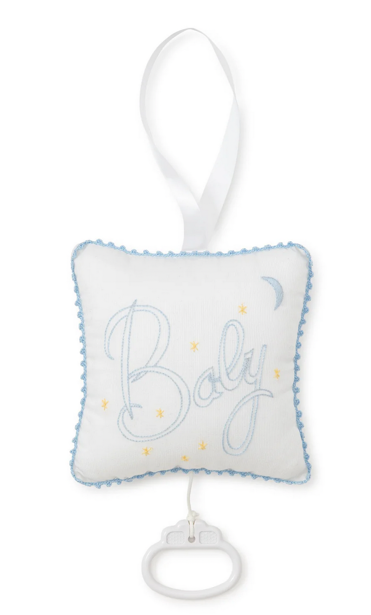 The Kissy Kissy Blue "Baby" Musical Pillow by Kissy Kissy is an enchanting gift for a baby, featuring star and moon decorations on a blue background. The word "Baby" is elegantly embroidered in blue on the white fabric. It includes a convenient pull tab and hangable ribbon, all beautifully packaged in a lovely tulle bag.