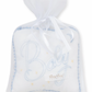 The Kissy Kissy Blue "Baby" Musical Pillow features a charming white sachet with a blue-stitched "Baby" design. It is elegantly trimmed with lace and tied with a white ribbon, making it an ideal baby gift. The delicate tulle bag adds an extra touch of charm.