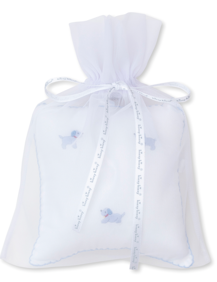 The Kissy Kissy Hand Embroidered Premier Puppies Musical Pillow with Tulle Bag in White/Light Blue includes a small pillow featuring blue hand-embroidered poodle designs, making it perfect for puppy friends. This delightful item is elegantly presented in a white sheer tulle gift bag with a ribbon tie.