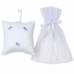 The Kissy Kissy Hand Embroidered Premier Puppies Musical Pillow with Tulle Bag in White/Light Blue features a small white pillow adorned with blue dog embroidery and intricate hand-embroidered detailing, complete with a hanging ribbon. It comes paired with a sheer white tulle bag secured by a ribbon tie, making it an ideal keepsake for puppy enthusiasts.