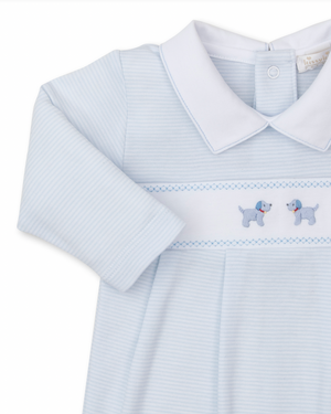 The Kissy Kissy Premier Hand Embroidered Puppies Playsuit by Kissy Kissy features a light blue baby onesie with a white collar and charming blue hand-embroidered dogs on the front. Crafted from soft Pima cotton, this playsuit ensures your little one's comfort and style.