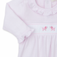 The Kissy Kissy Premier Hand Embroidered Puppies Playsuit by Kissy Kissy is a pink long-sleeve baby dress made from soft Pima cotton, featuring a ruffled collar and cuffs, and adorned with hand-embroidered pink poodles on the front.