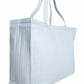 The Minnow Overnighter Tote by Minnow is a large reusable shopping bag featuring a blue and white striped pattern, a spacious interior, quilted fabric, and two handles for easy carrying.