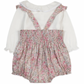 The Tartine et Chocolat Ensemble Court Liberty Pink Overall Top Set by Tartine et Chocolat is a baby's outfit featuring a white long-sleeved top with ruffled cuffs and a pale pink floral romper adorned with smocked details, delicate embroidery, and suspenders.