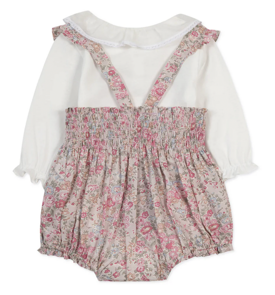 The Tartine et Chocolat Ensemble Court Liberty Pink Overall Top Set by Tartine et Chocolat is a baby's outfit featuring a white long-sleeved top with ruffled cuffs and a pale pink floral romper adorned with smocked details, delicate embroidery, and suspenders.