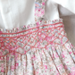 Close-up of the Tartine et Chocolat Ensemble Court Liberty Pink Overall Top Set with pink and blue smocking details against a white background, showcasing the delicate embroidery by Tartine et Chocolat that enhances its charm.