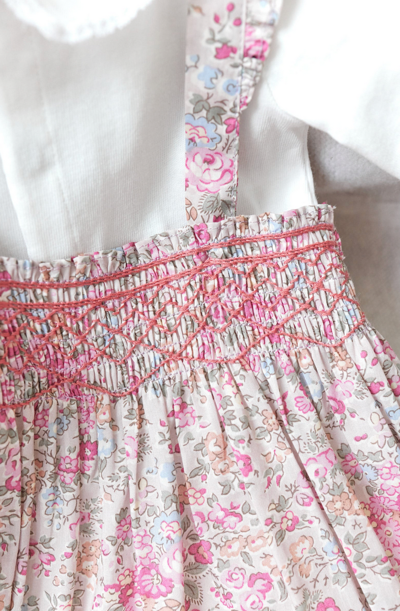 Close-up of the Tartine et Chocolat Ensemble Court Liberty Pink Overall Top Set with pink and blue smocking details against a white background, showcasing the delicate embroidery by Tartine et Chocolat that enhances its charm.