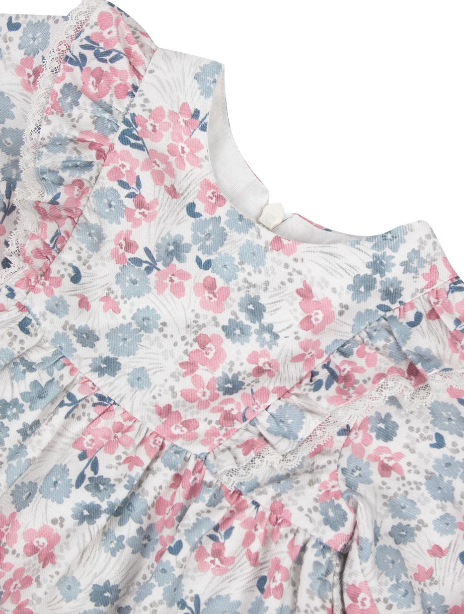 Close-up of the Tartine et Chocolat Rasberry Printed Flowery Dress for baby girls, featuring a charming floral pattern with pink and blue flowers. This dress has short sleeves and a white neckline adorned with lace trim, making it perfect for winter outfits. Crafted from high-quality fabric by Tartine et Chocolat, it ensures both comfort and durability.