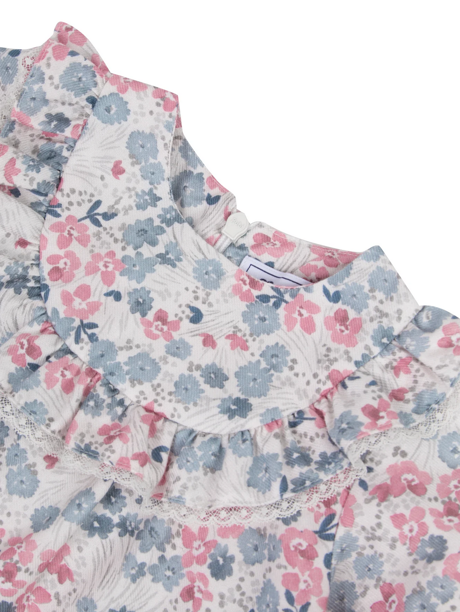 Close-up of a Tartine et Chocolat Raspberry Printed Floral Blouse, showcasing a delightful pink and blue flowery pattern. The blouse features elegant ruffled details along the collar and neckline, accented by delicate raspberry tones.