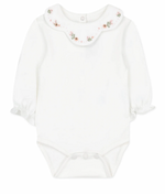 A long-sleeved white baby onesie with an embroidered flower collar and snap buttons at the bottom from Tartine et Chocolat.