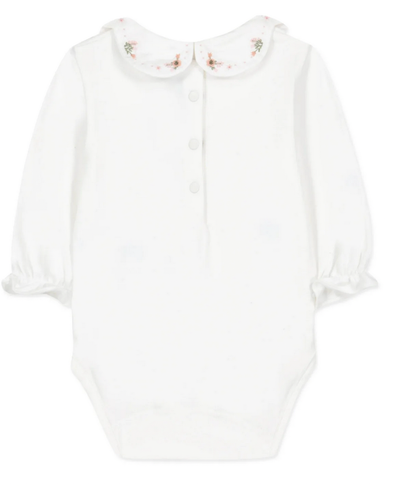 White long-sleeve baby onesie from Tartine et Chocolat, featuring an embroidered flower collar and floral trim embellishments.