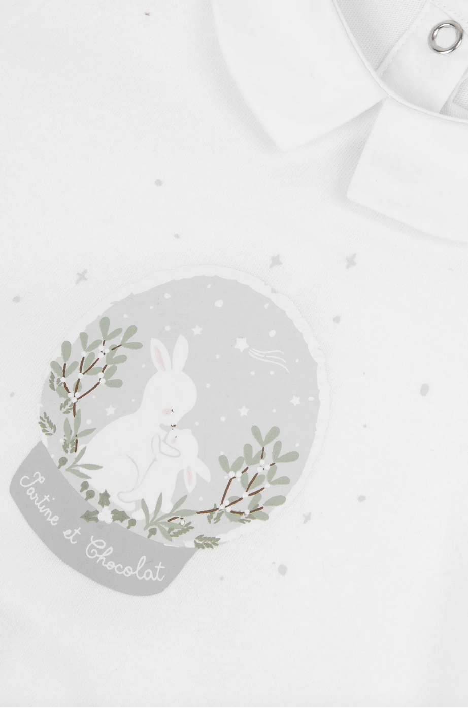 The Tartine et Chocolat Pyjama Snowball Bunny Onesie features a printed design of two white rabbits embracing under a night sky, surrounded by green foliage and stars. Made from 100% cotton, it's perfect for pajamas or casual wear. The text below the image reads "Tartine et Chocolat," making it an adorable choice for newborns.