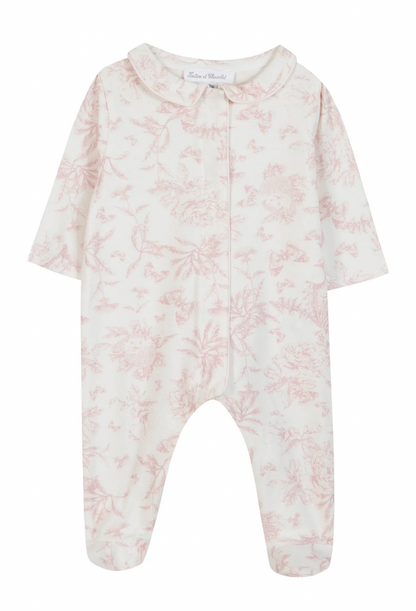 The Tartine et Chocolat Pale Pink Toile Pyjama by Tartine et Chocolat is a long-sleeved white baby onesie adorned with a delicate pale pink floral pattern and featuring a charming Peter Pan collar. Crafted from soft and comfortable fabric, it's perfect for baby girl pajamas.