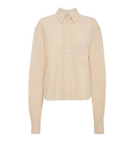 The Ellys Shirt by Victoria Beckham is a long-sleeve, light beige collared shirt featuring a classic button-up front, chest pocket, straight hem, and subtle embroidered detailing, shown against a plain white background.