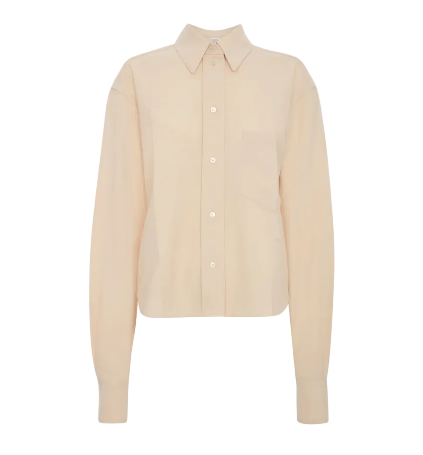 The Ellys Shirt by Victoria Beckham is a long-sleeve, light beige collared shirt featuring a classic button-up front, chest pocket, straight hem, and subtle embroidered detailing, shown against a plain white background.