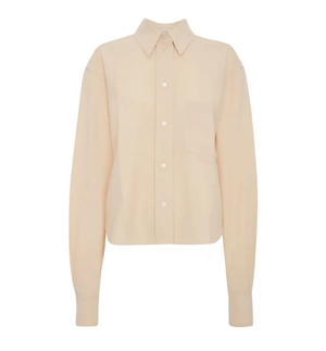 The Ellys Shirt by Victoria Beckham is a long-sleeve, light beige collared shirt featuring a classic button-up front, chest pocket, straight hem, and subtle embroidered detailing, shown against a plain white background.