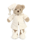 Briar Bedtime Bear by Mon Ami stands upright against a white background, dressed in a cream-colored robe, matching night cap, and cute bunny plush slippers.