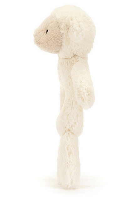 A side view of the Jellycat Bashful Lamb Ring Rattle with a round head, small ears, and a beige face, standing upright. Crafted from recycled fibers, this charming Jellycat toy also doubles as a gentle baby rattle.