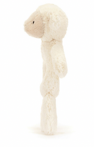 A side view of the Jellycat Bashful Lamb Ring Rattle with a round head, small ears, and a beige face, standing upright. Crafted from recycled fibers, this charming Jellycat toy also doubles as a gentle baby rattle.