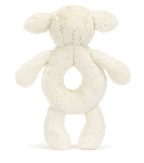 A back view of a Jellycat Bashful Lamb Ring Rattle with a round open space in the middle and four limbs, all covered in white fur made from recycled fibers.