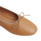 A close-up view of a tan Mansur Gavriel Dream Ballerina flat with a bow on the front, crafted from supple Italian lambskin leather.