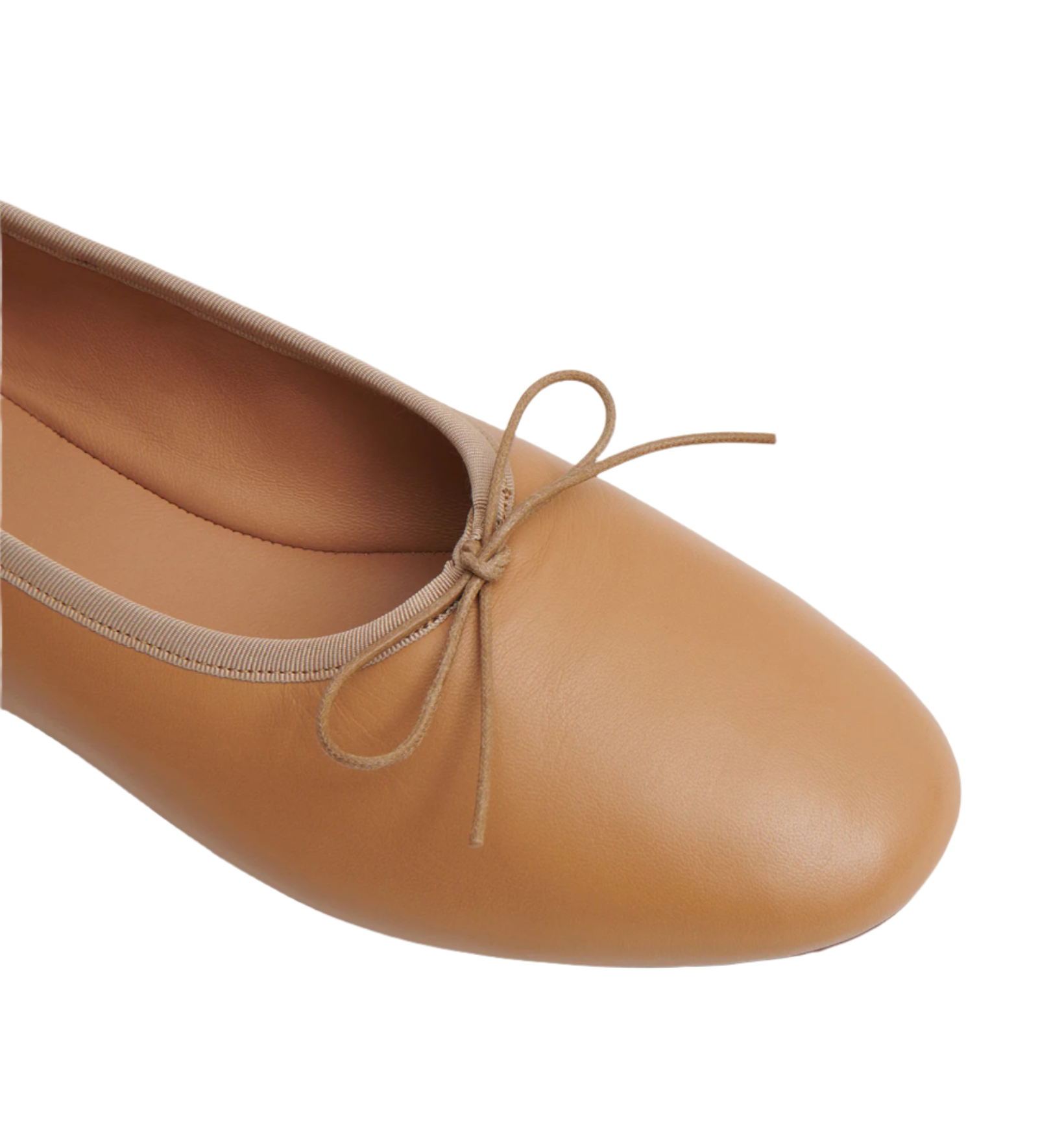 A close-up view of a tan Mansur Gavriel Dream Ballerina flat with a bow on the front, crafted from supple Italian lambskin leather.