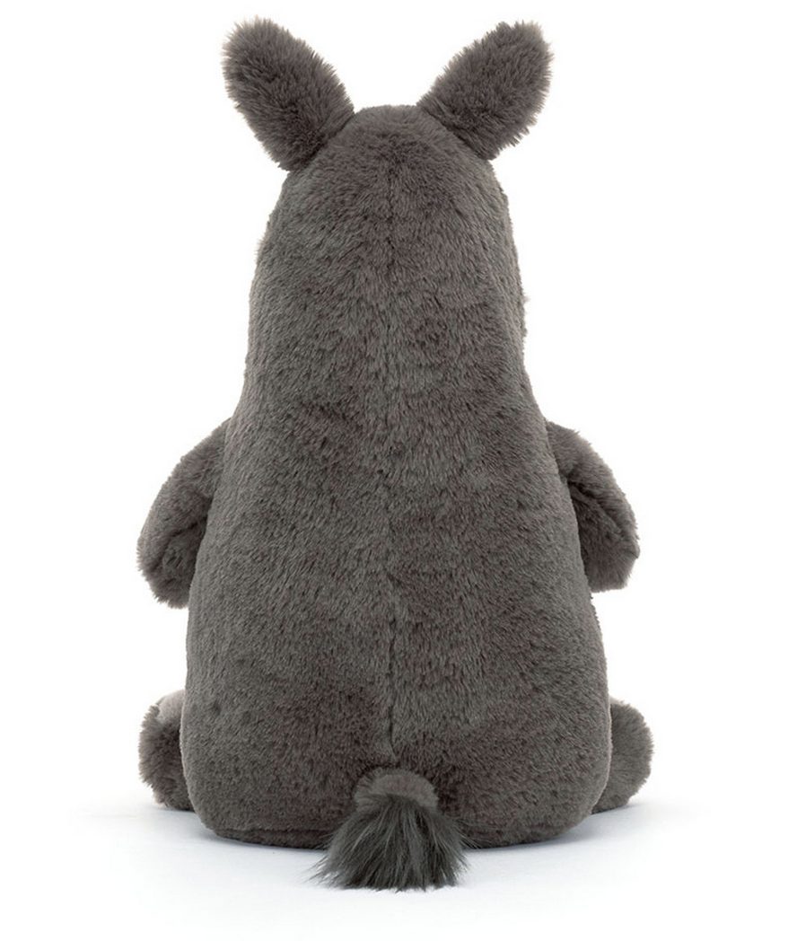 A sturdy plush toy, this fluffy, grey stuffed animal with soft fur features two ears and a short tail. Shown from the back, the Jellycat Roderick Rhinoceros remains seated and appears incredibly plush.