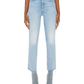 Person wearing light blue Mother Denim The Hustler Ankle Fray jeans with raw hems, light gray pointed-toe boots, and a white cropped top, standing against a plain white background.