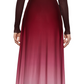 A person wearing a Prabal Gurung Twist Front Long Sleeve Dress featuring an ombre design transitioning from burgundy to pink, paired with black boots, seen from behind.