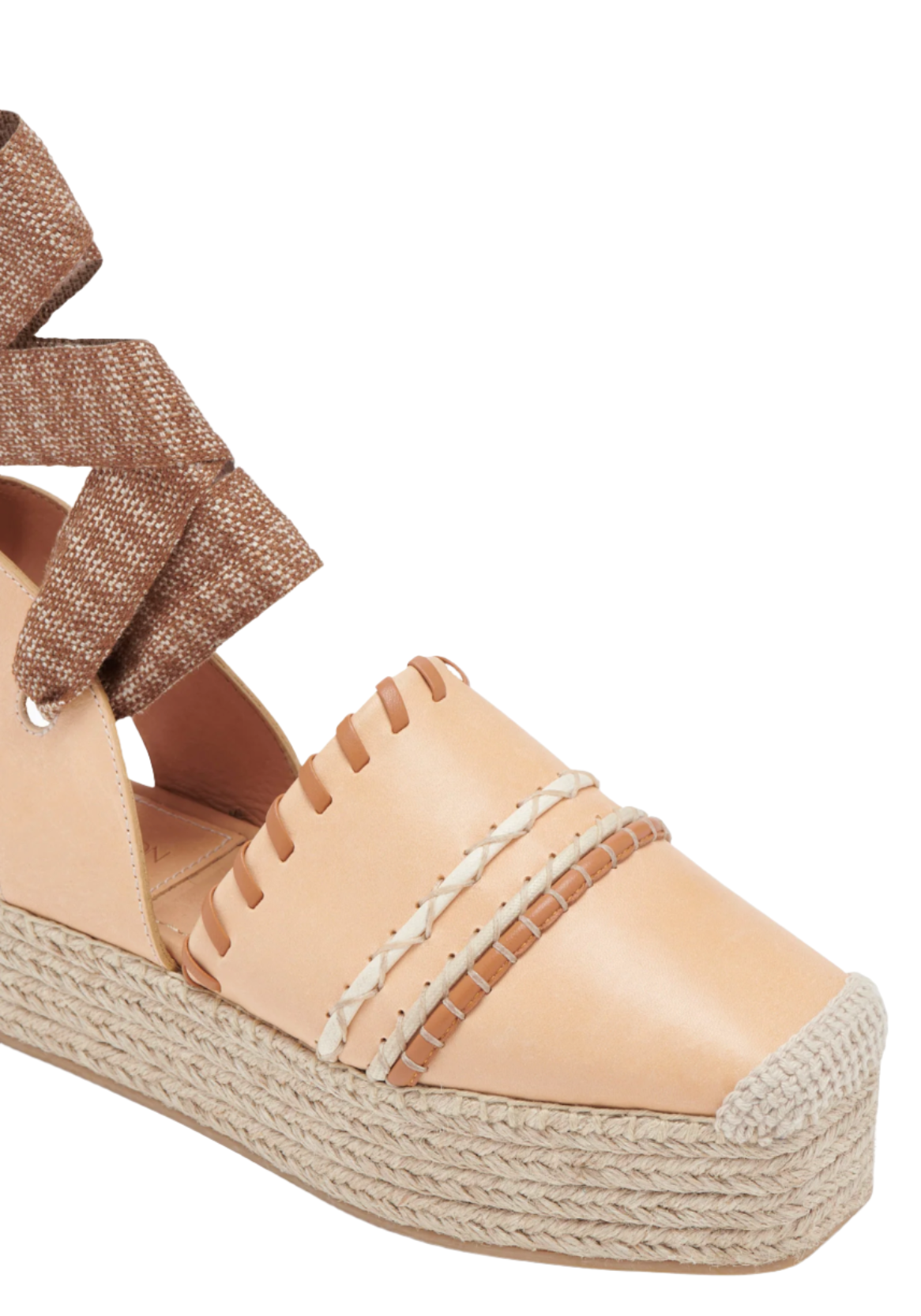 Close-up of a tan Ulla Johnson Concha Platform Espadrille with woven leather and fabric details on the upper section, featuring a beige jute platform.