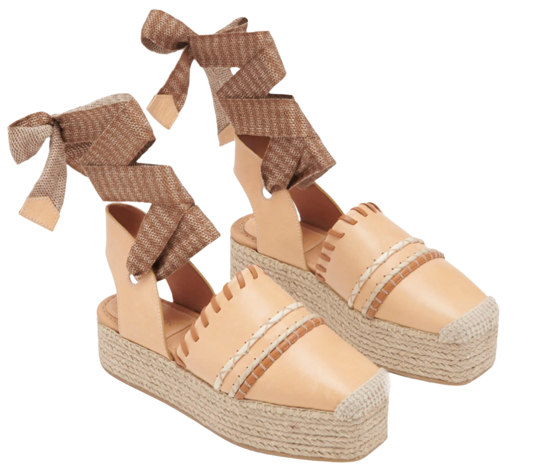 Ulla Johnson Concha Platform Espadrille by Ulla Johnson with woven rope soles and brown ribbon ankle ties. The shoes have a two-tone design, featuring decorative stitching on the upper and a stylish jute platform for added height.