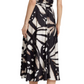 A person wearing a Prabal Gurung Flutter Slv Twist Dress in black and white abstract print with short sleeves and black high-heeled sandals is seen from the back.