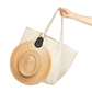 A hand displays a beige tote bag equipped with the Toptote The Fray Raffia Hat Clip, providing a smart travel solution for organizing your accessories in style.