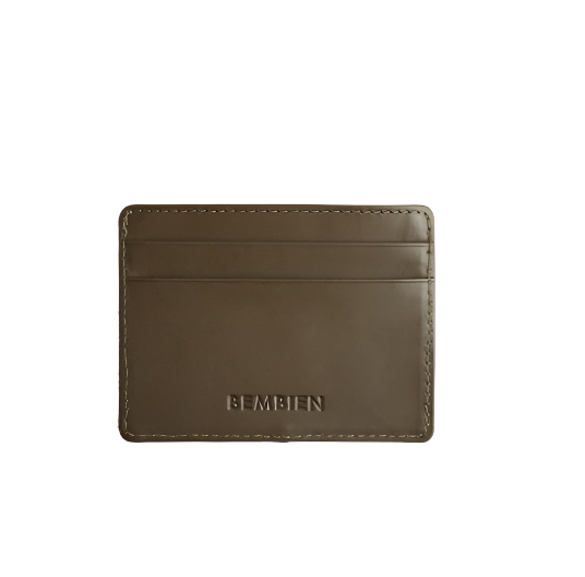 The Bembien Nico Card Case, crafted from brown leather, showcases a minimalist design with two card slots and the brand's name elegantly embossed on the front. This sleek card case combines style and functionality, making it a perfect accessory for daily use.