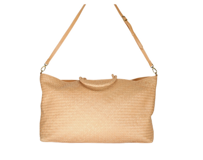 The Bembien Le Traveler by Bembien is a beige, large woven tote bag made from cow leather, featuring tan leather handles and an adjustable shoulder strap. Perfect as a stylish carry-on.